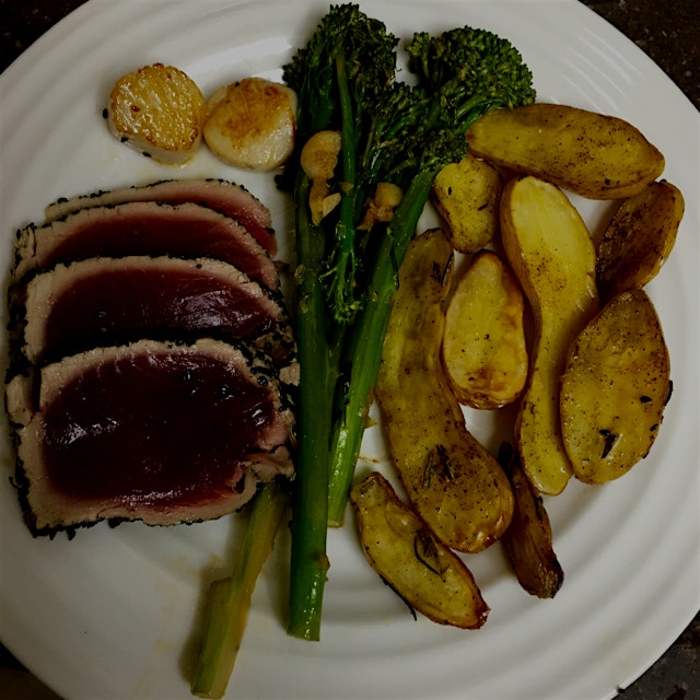 Special Sunday night family meal. Grilled Tuna coated with sesame seeds, broccolini with garlic, ...