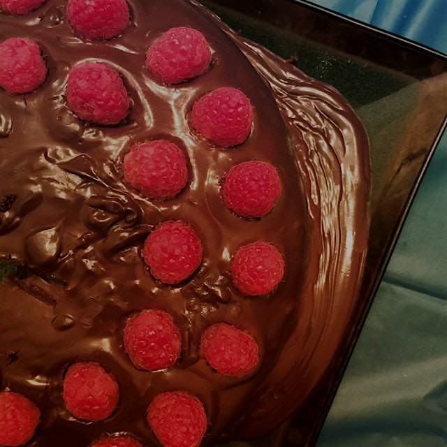 Homemade double chocolate cake with chocolate ganache and fresh raspberries.
