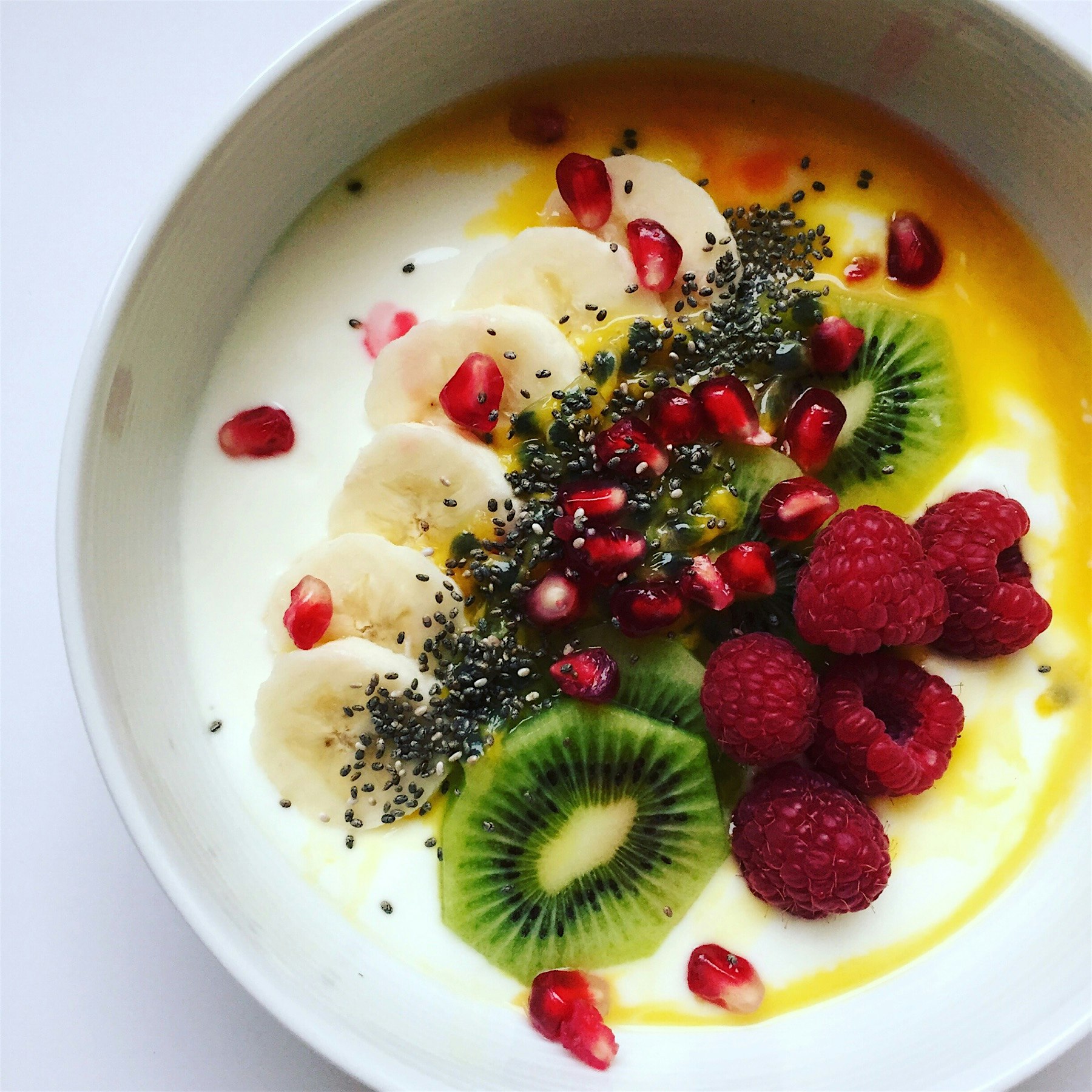 Yogurt bowl with passion fruit, chia seeds, kiwi, banana, pomegranate and raspberries 