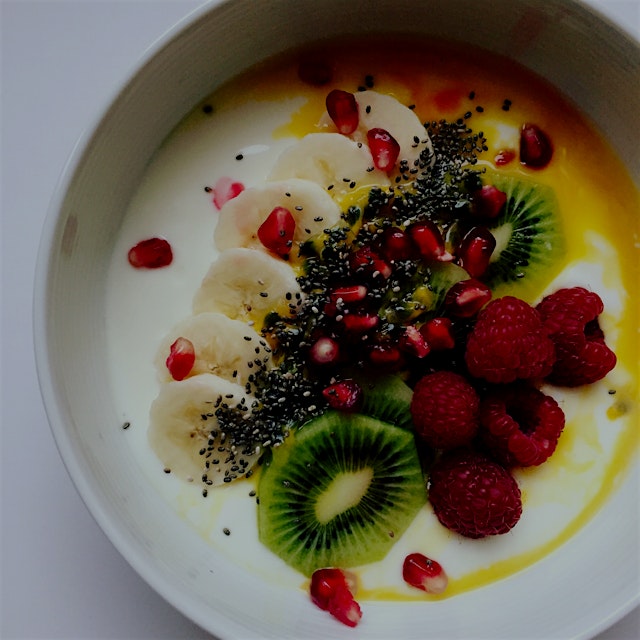 Yogurt bowl with passion fruit, chia seeds, kiwi, banana, pomegranate and raspberries 