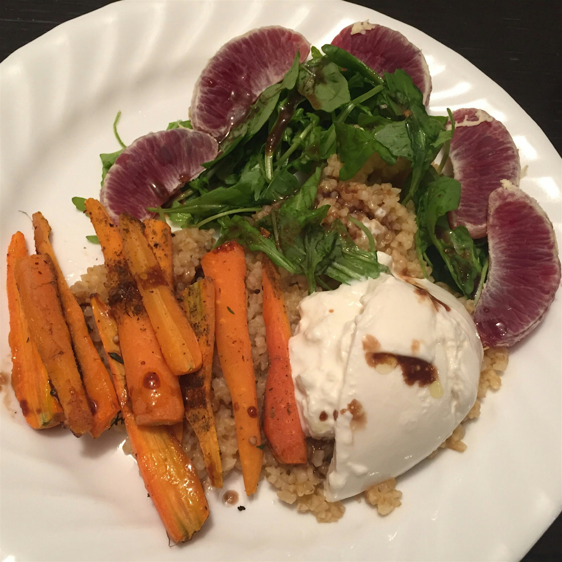 Roasted carrots with burrata, arugula and blood oranges over bulgar. 