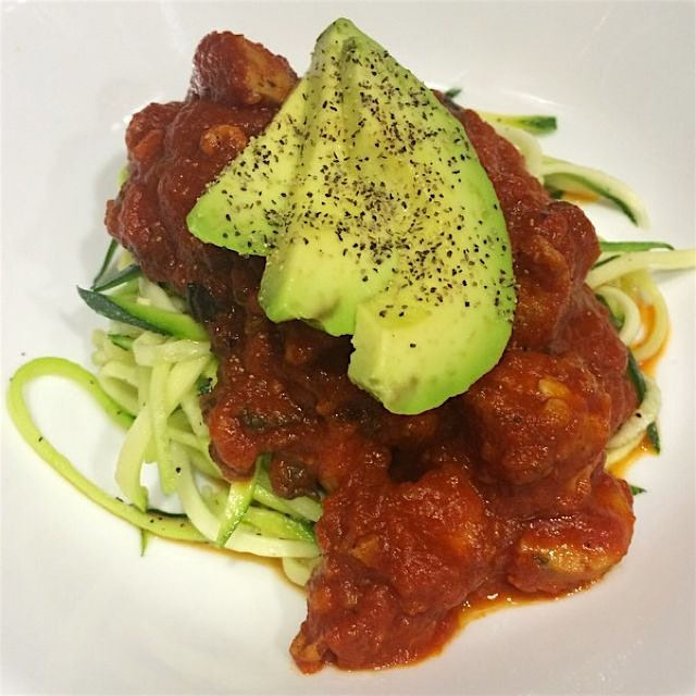 Zoodles with homemade meat sauce, topped with avocados. Paleolithic diet, whole 30 compliant. Sim...