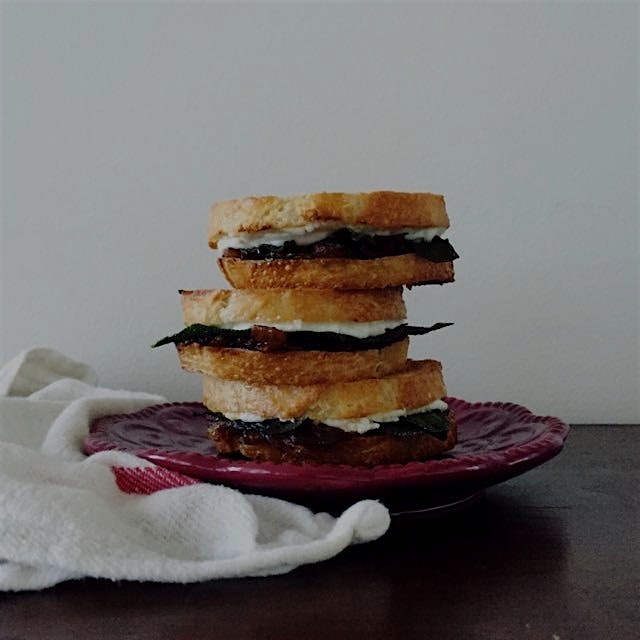 Little grilled goat cheese sandwiches with caramelized onions and crispy sage on locally made fre...