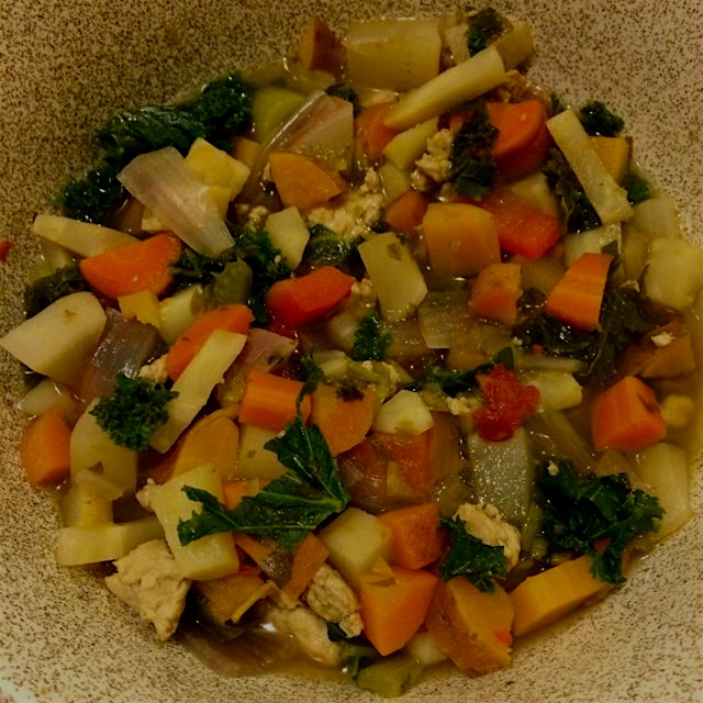 Hearty root vegetable soup with ground turkey, red peppers and kale, all cooked in a sofrito brot...