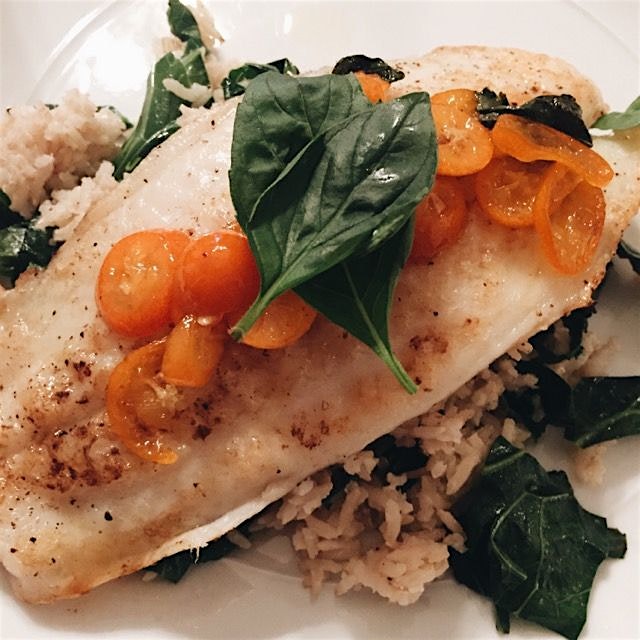 Catfish over brown rice and collard greens with a kumquat-chile glaze and fresh Thai basil on top 🍊🌿
