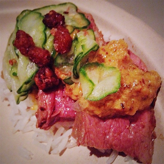 Seared medium-rare duck breast with Rendang sauce over a coconut rice disc, quick-pickled cukes a...