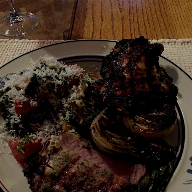 Dry aged pork chops with sofrito, charred spring onions, tomato avocado salad with fresh basil an...