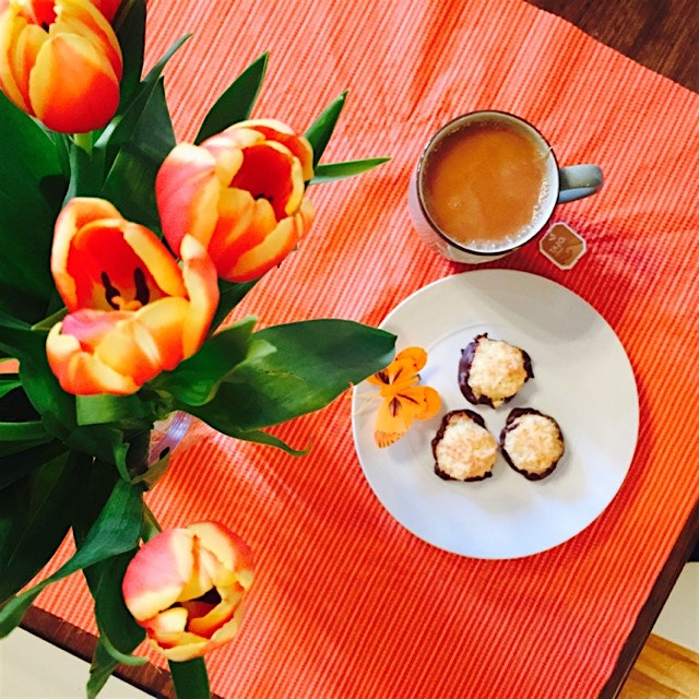 Orange macarons dipped in dark chocolate, chai tea, and tulips 🌷