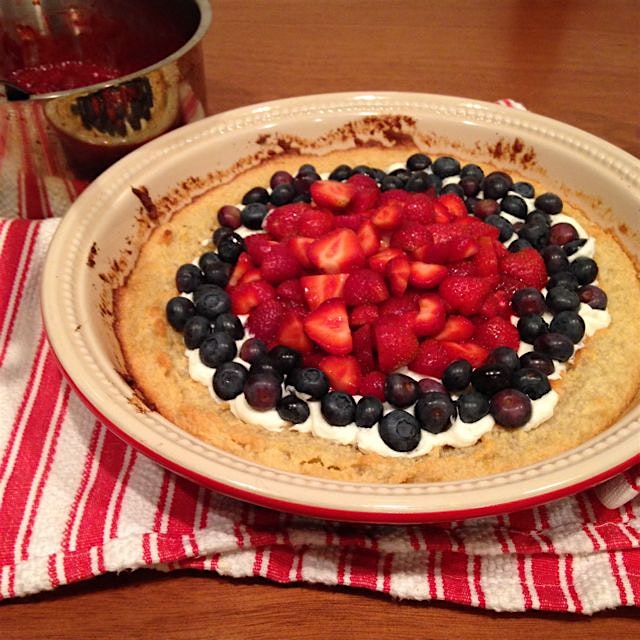 Honeyed-goat cheese almond crust tart topped with still warm jam, strawberries and blueberries pi...