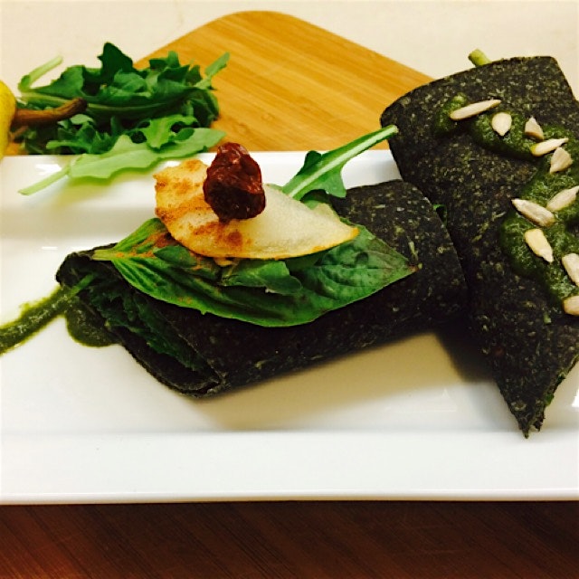Raw sprouted spirulina wrap with pesto rubbed greens, pear and cashew cream cheese 