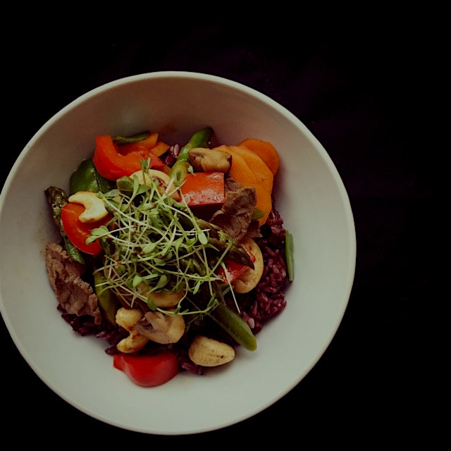 Stir-fried veggies with beef and cashew nut on black rice, topped with the alfalfa sprouts from o...