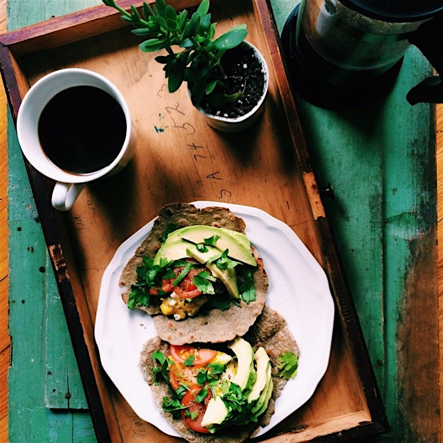 Red millet wraps with scrambled egg, tomato and avocado slices, generously covered with lemon jui...