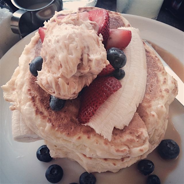 Ricotta Pancakes with honeycomb butter, fresh banana, blueberries, strawberries, and pure maple s...