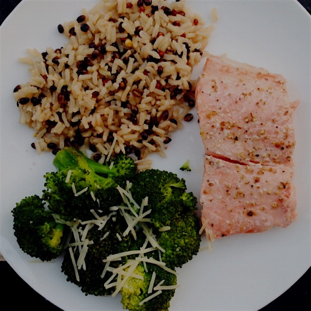 Salmon, brown rice medley (brown rice, black barley, and daikon radish seeds), and broccoli. To l...