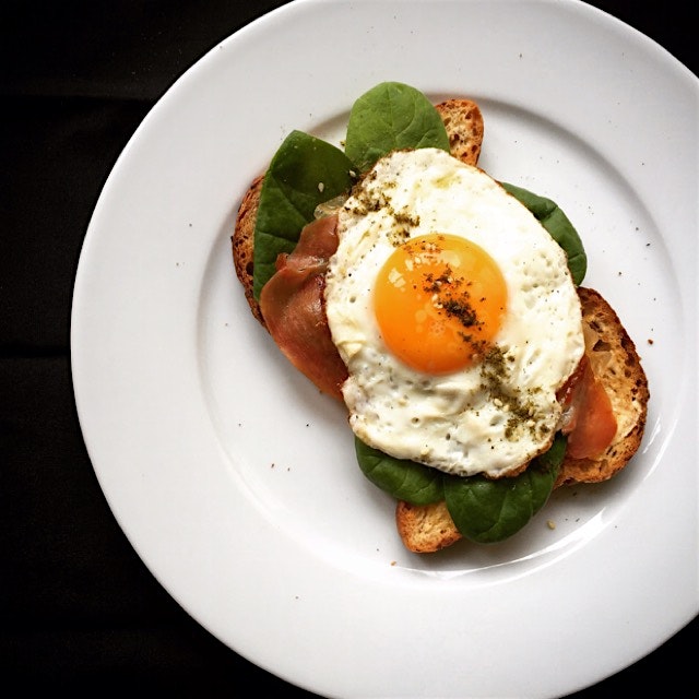 Crispy Serrano, baby spinach and a fried egg on gluten free toasts, with a sprinkle of za'atar 