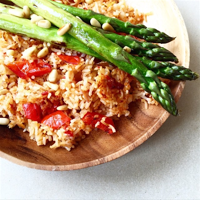Tamari sautéed asparagus with toasted pine nuts served on crispy tomato rice