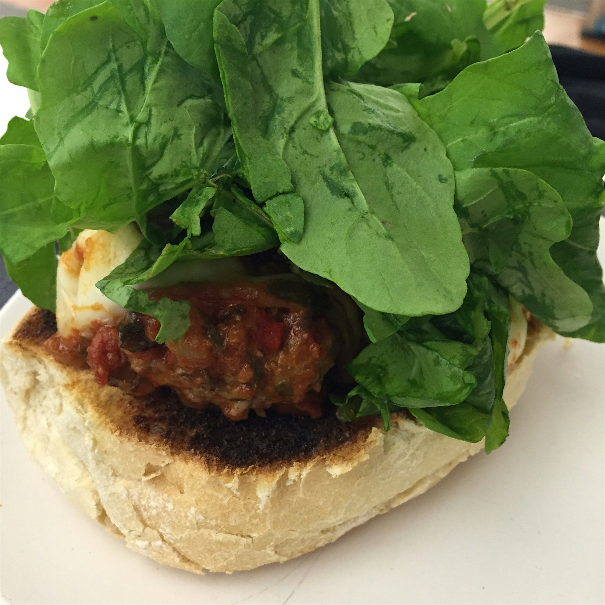 A perfect lunch: Leftover meatballs on half a brioche, topped with freshly washed arugula from th...