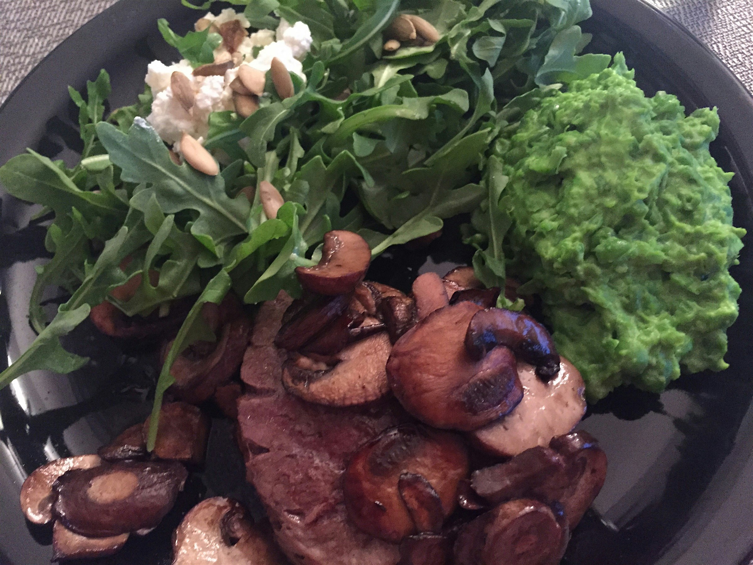 Dinner steak with mushrooms, pea mush and arugula with ricotta and sunflower seeds 