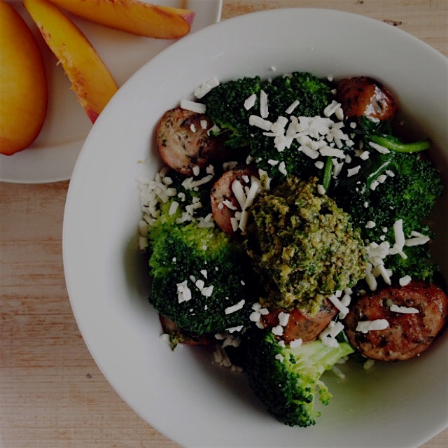 Chicken sausage, steamed broccoli, and sautéed spinach bowl with feta and topped with a big dollo...