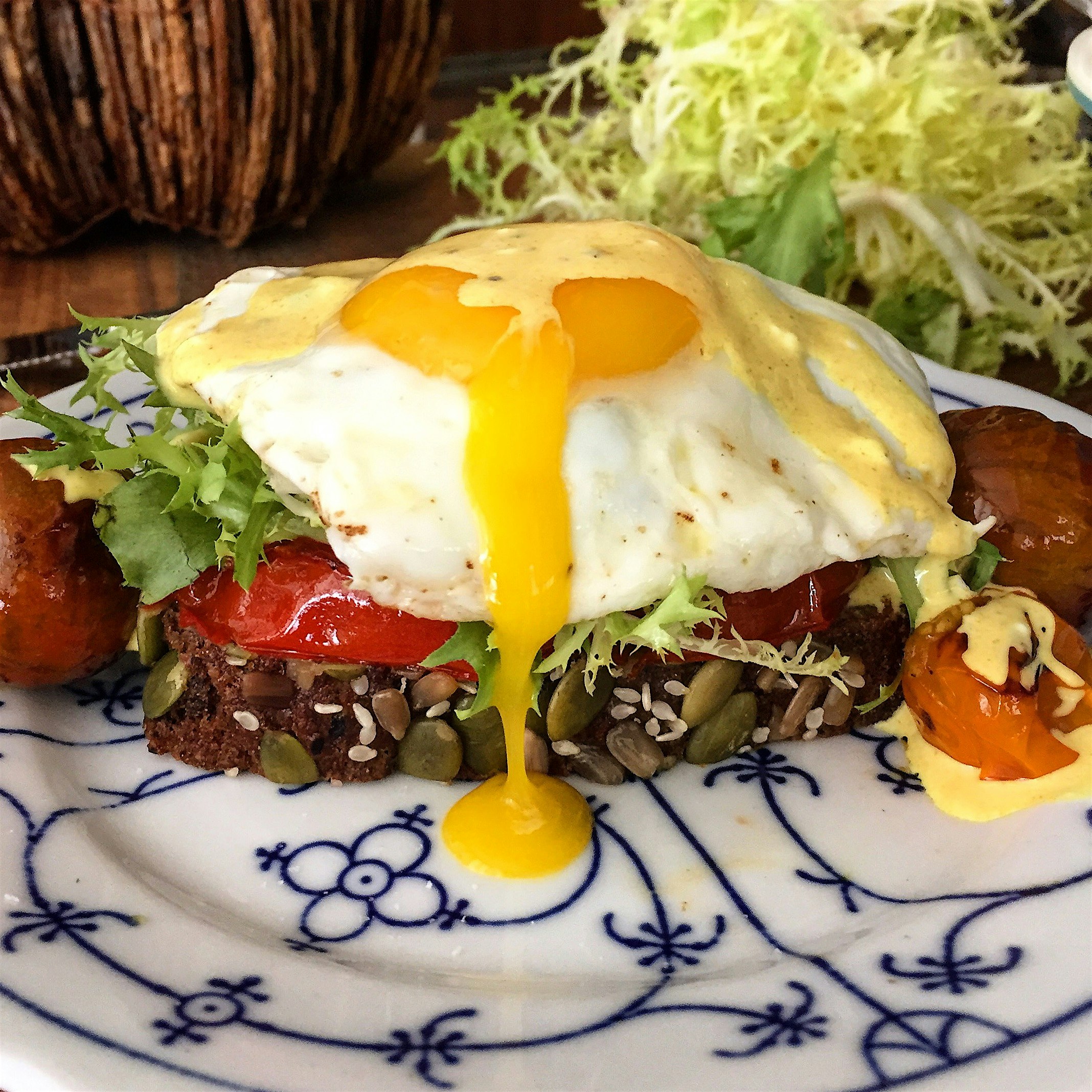 Muh egg is leaking. 
Homemade chestnut seed bread, frisée, roasted tomato, egg and 'fauxlandaise'...