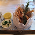 A classy basket of fried frog legs with sprig of fried rosemary.