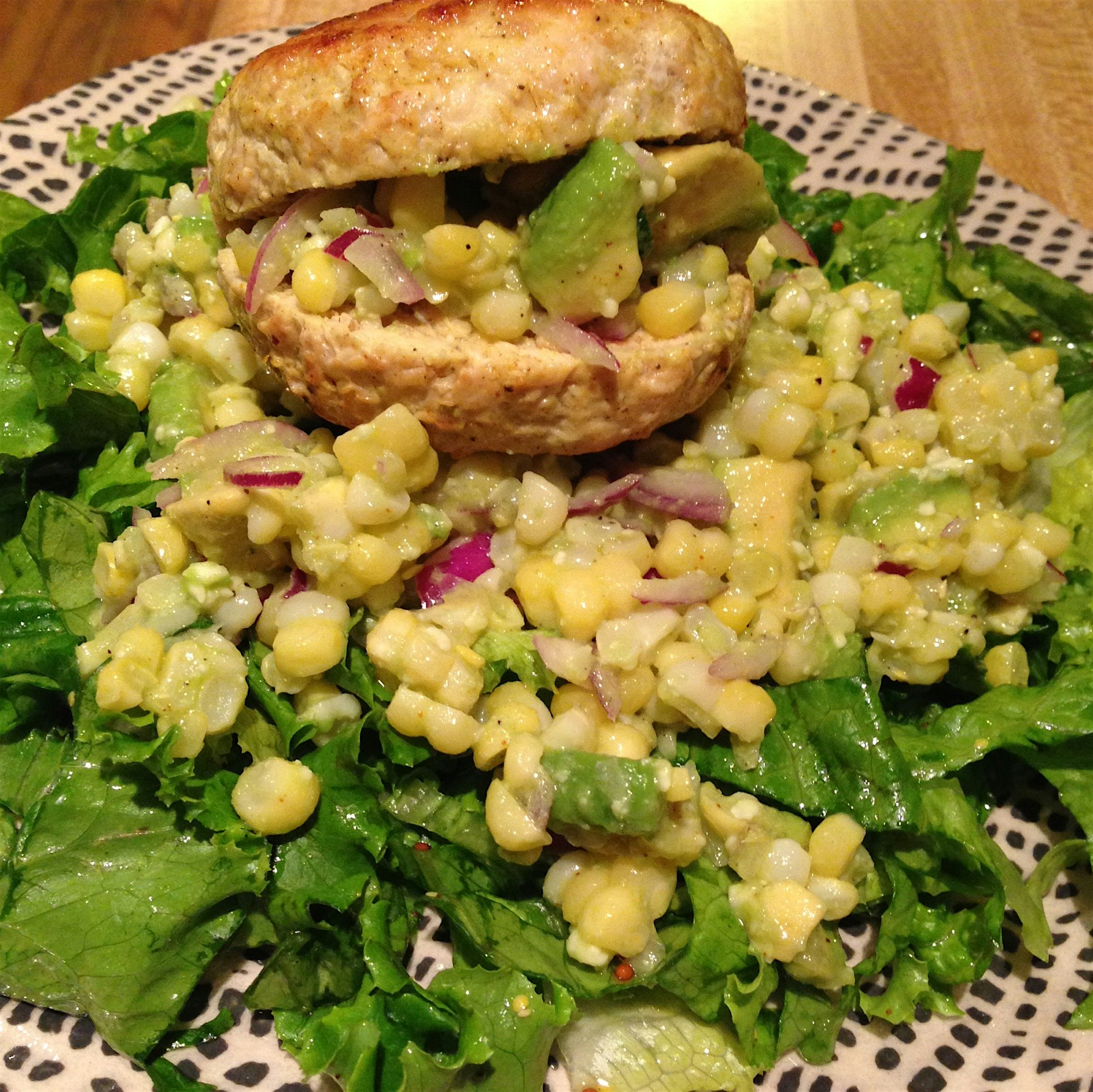 Alberto's night to cook! Tender, local chicken burger atop corn salad laced with red onion in hon...
