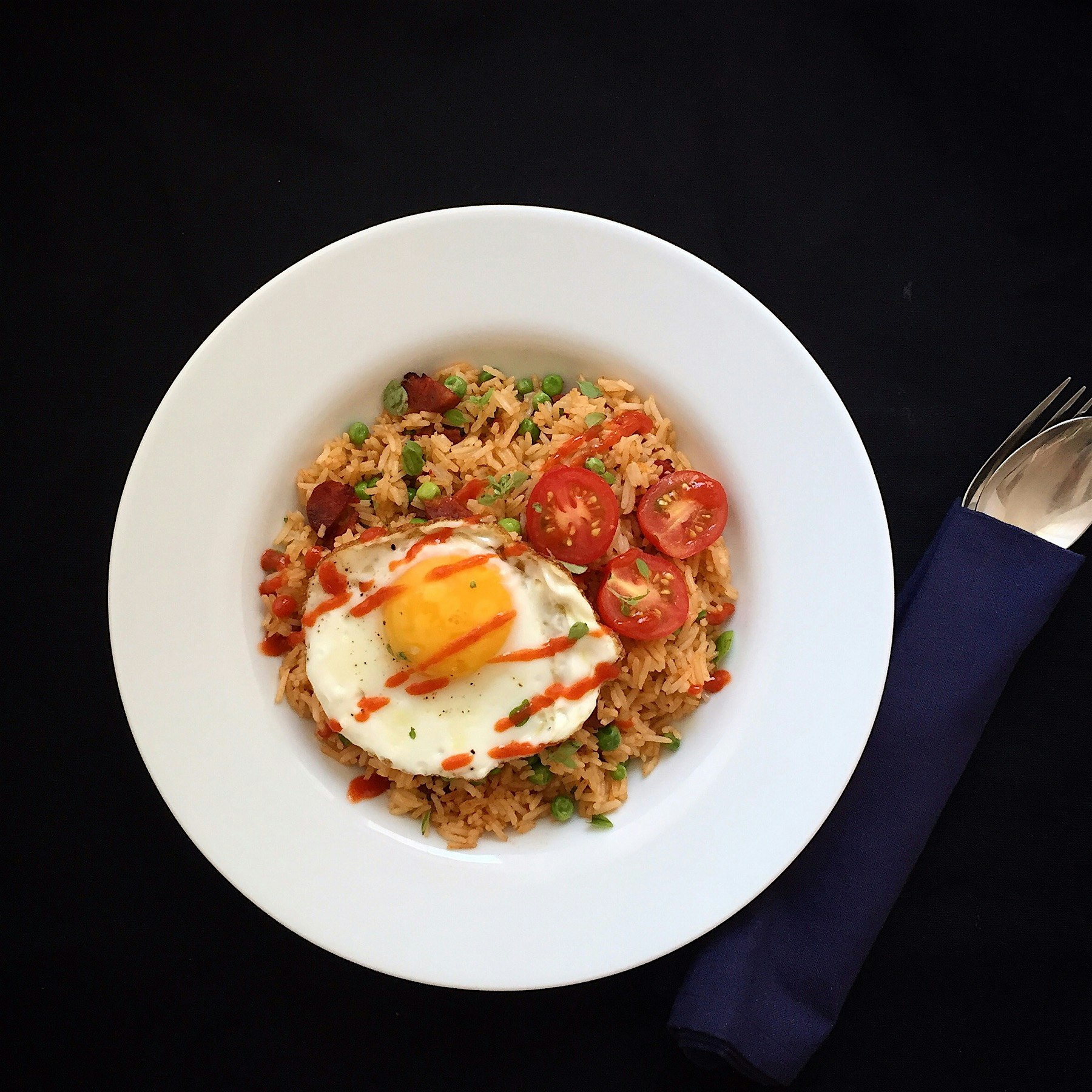 My lunch today: chorizo and peas fried rice with a fried egg on top, and plenty of sriracha 