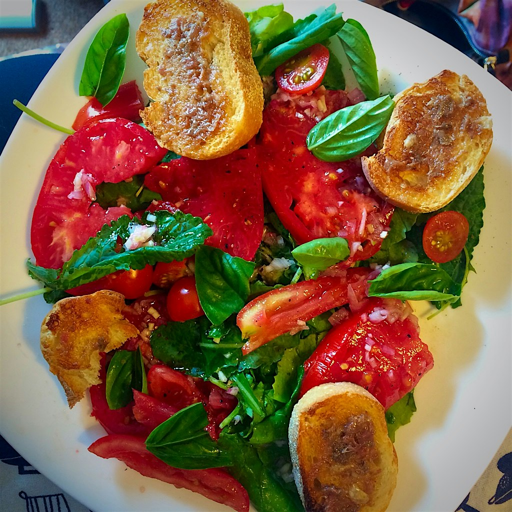 Tomato salad over baby kale with garlic-anchovy toasts: garden-fresh tomatoes, not-so-fresh breath!