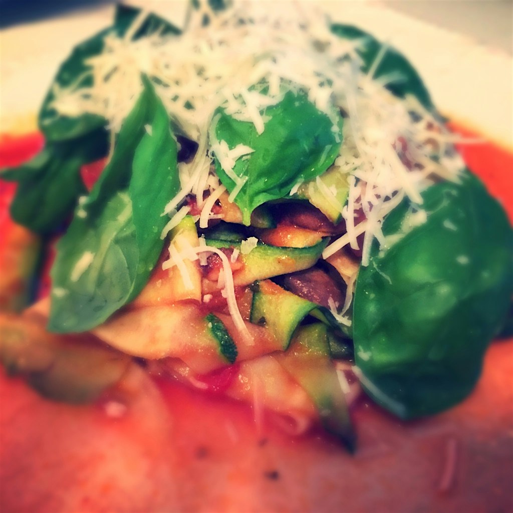 Healthy homemade dinner zucchini spaghetti style with sausage mushrooms basil and Parmesan 