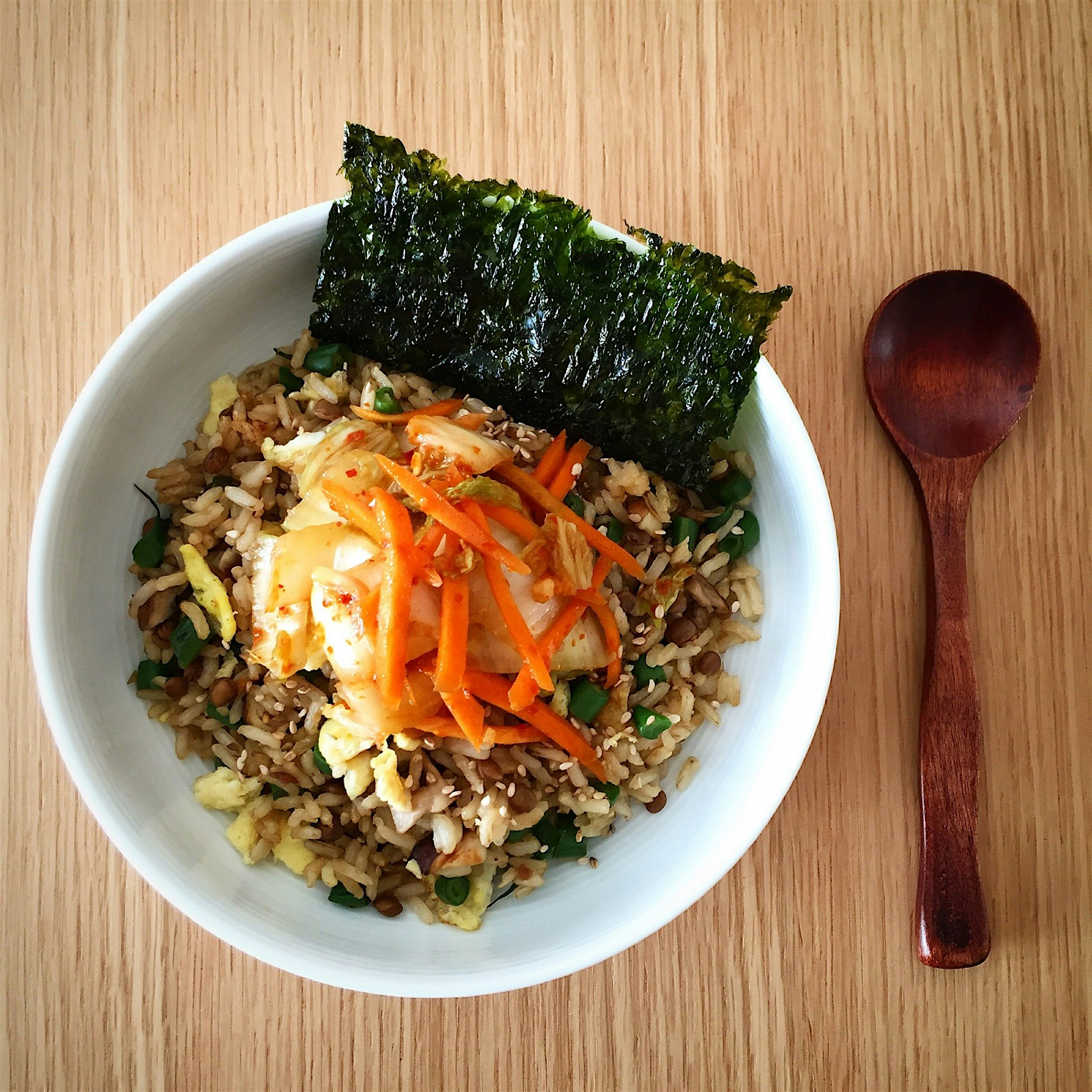 Veggies fried rice topped with homemade kimchi, served with toasted nori