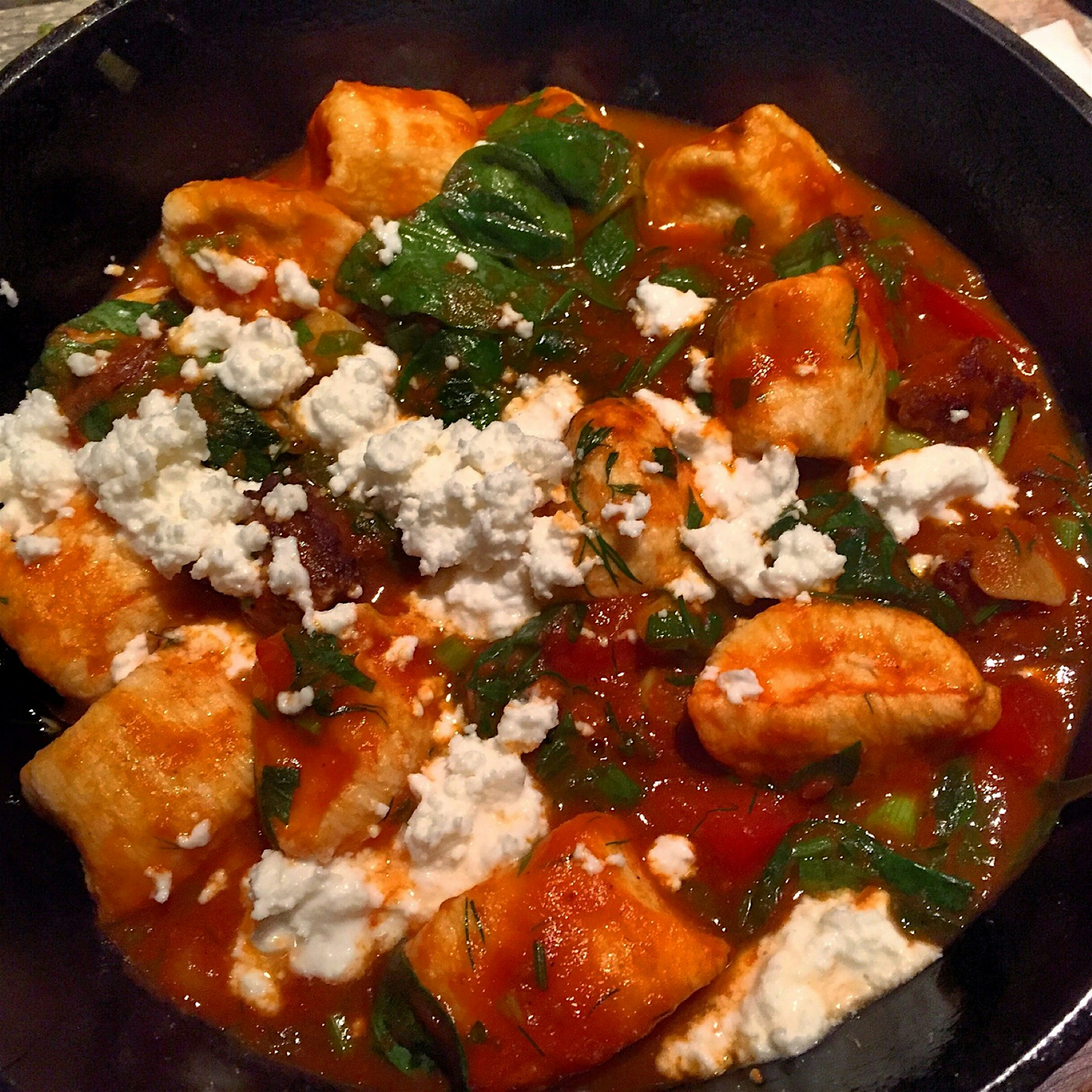 Dumplings with spicy lamb sausage, sun-dried tomato, pine nut, spinach, tomato and feta. Greek fo...