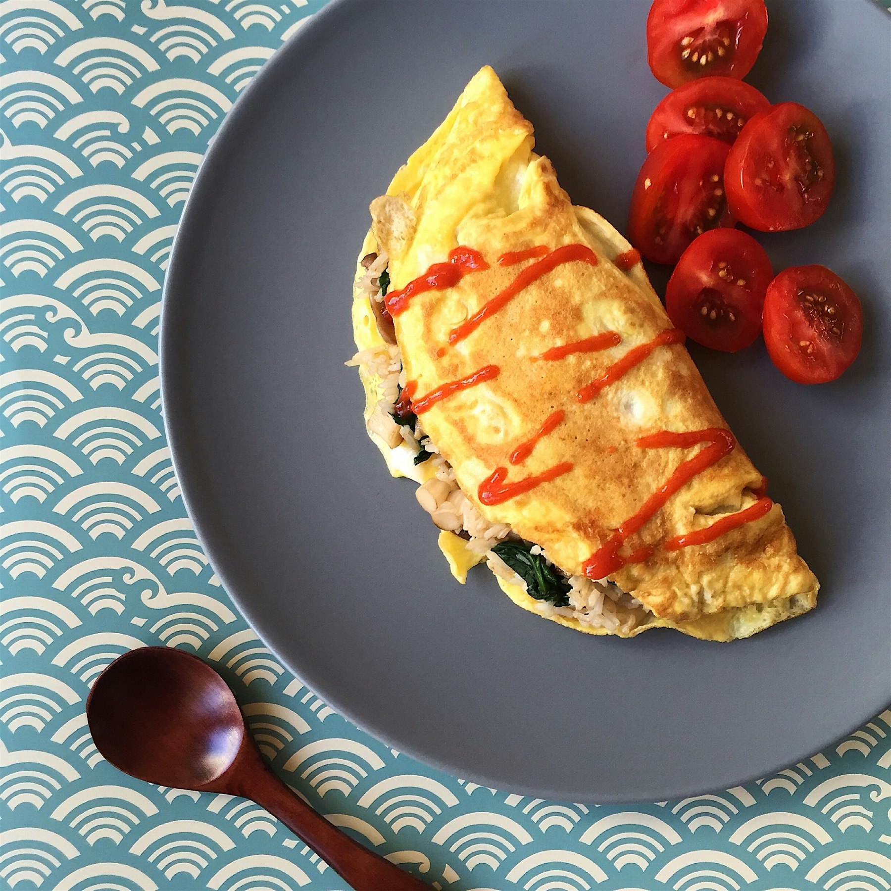 Kind of Omurice: mushrooms and spinach fried rice wrapped in omelette, topped with Sriracha 